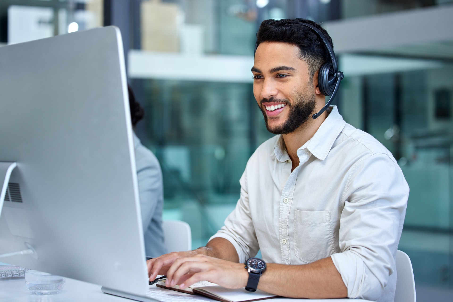 Tiro de um homem de negócios usando um computador enquanto trabalhava em um call center